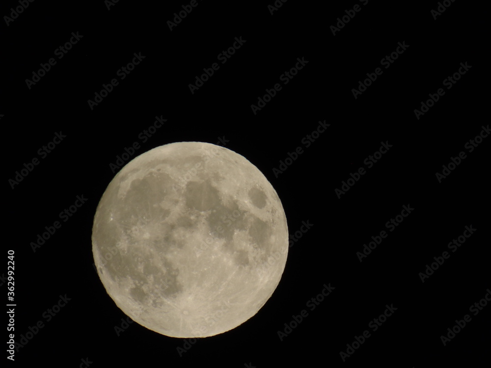 Genova, Italy - 07/05/2020: An amazing photography of the full moon over the city of Genova by night with a great clear and blue sky in the background and some stars. Genova, Italy - 07/05/2020: An amazing photography of the full moon over the city of Genova by night with a great clear and blue sky in the background and some stars.