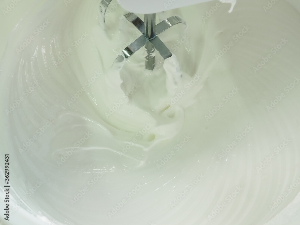 beat the cream for the cake with a mixer. poster. beat the cream for the cake with a mixer. poster.