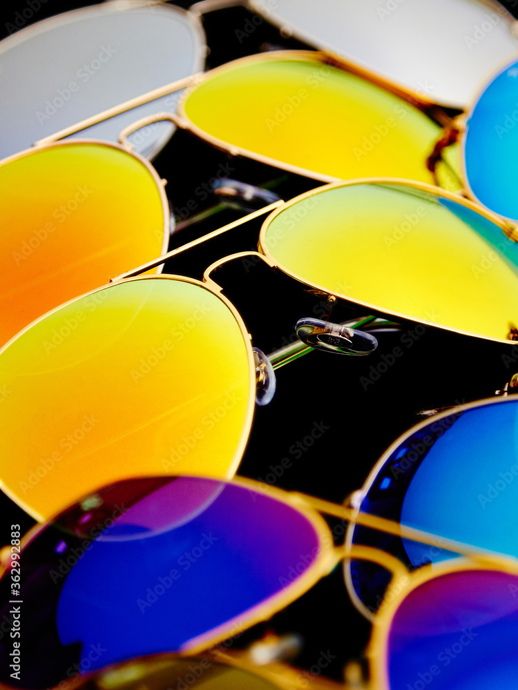Sunglasses with colorful lenses on black background
