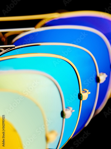 Obraz na płótnie Sunglasses with colorful lenses on black background w salonie