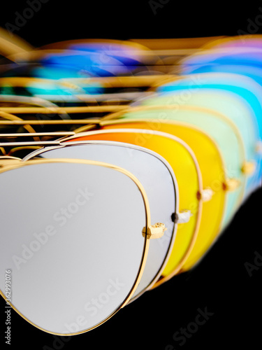Obraz na płótnie Sunglasses with colorful lenses on black background w salonie