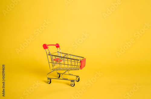 Empty metal food cart on yellow isolated background with space for text