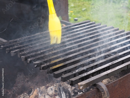 Smoking grill grate smeared with oil. smoke. outdoor recreation.