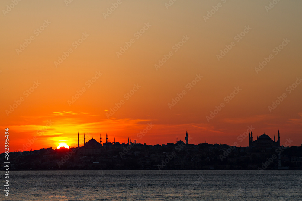 Silhouette of Istanbul with the domes and minarets of Blue Mosque and Hagia Sophia, at the sunset, from Bosphorus, Turkey