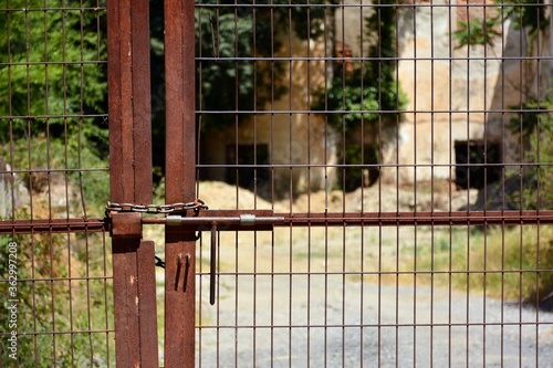puerta de valla de hierro,  cerrada con cerrojo y candado