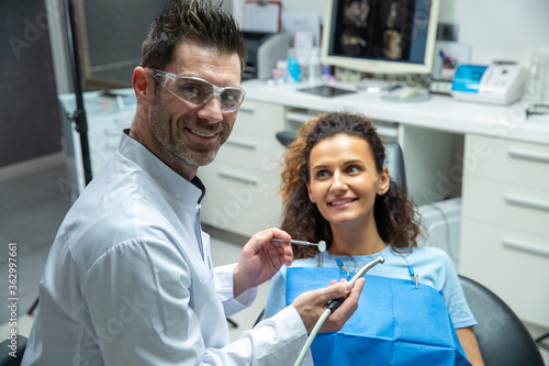 Attractive young woman in stomatology clinic with male dentist. Healthy teeth concept. 