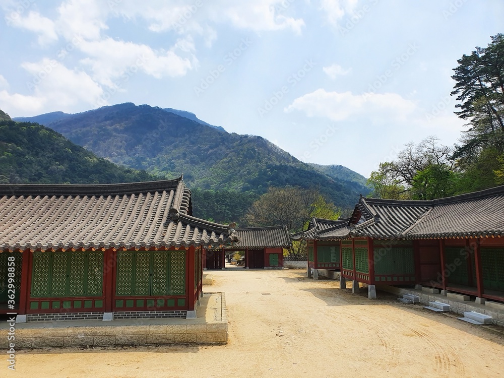 Small Korean buildings with a forested mountain in the distance