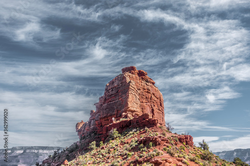 A majestic red rock formation stands tall with a dramatic sky in the background in Grand Canyon National Park, Arizona, USA
