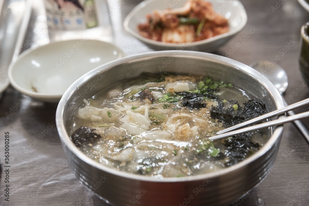 Closeup shot of a bowl with tasty Korean noodle soup at a restaurant