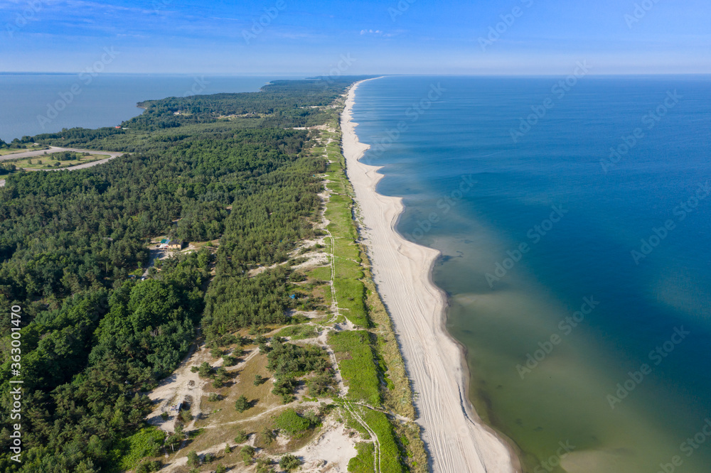 Beautiful view from the top of the Baltic (Vislin) spit. The sandy beach washed by the Baltic sea goes into the distance. Shot on a drone.