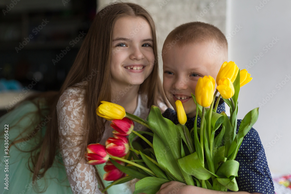 brother and sister are sitting with a bouquet of flowers brother and sister are sitting with a bouquet of flowers
