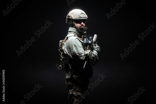 American soldier in military uniform with a weapon standing against a dark background, elite troops, American special forces