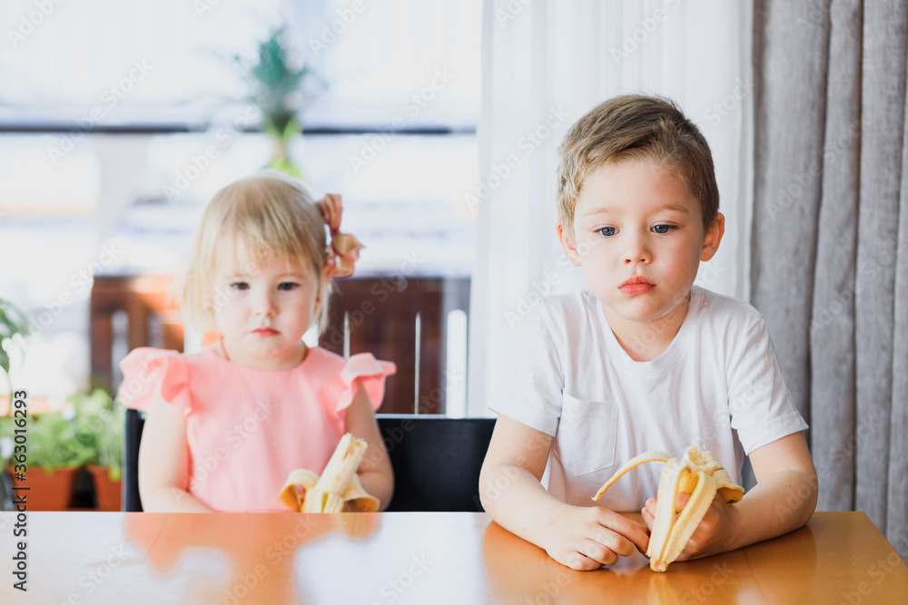 A girl and a boy eating a banana. A girl and a boy eating a banana.