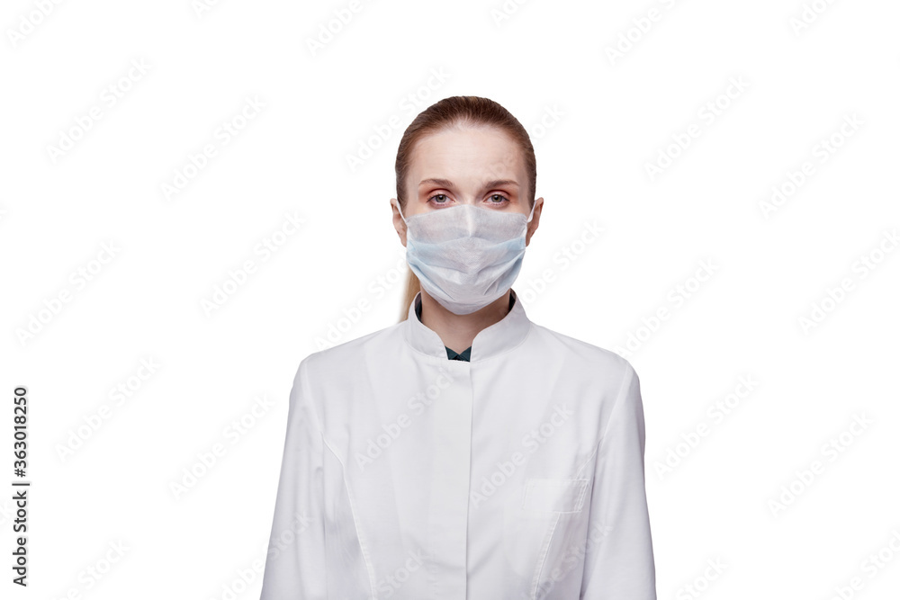A female doctor, looking at the camera, puts a medical mask on her face. A female doctor, looking at the camera, puts a medical mask on her face.