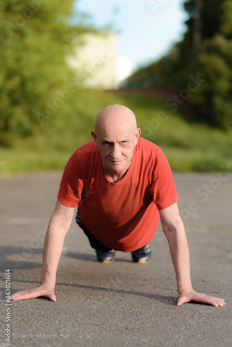 Senior sportsman doing push-ups in the park. High quality photo