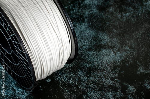 Filament for 3d printing. Bright thermoplastic of white color. Reel vertical view.