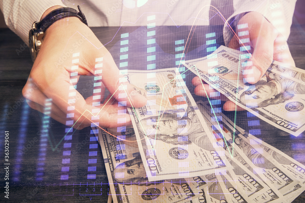 Multi exposure of financial graph drawing hologram and USA dollars bills and man hands. Analysis concept. Multi exposure of financial graph drawing hologram and USA dollars bills and man hands. Analysis concept.