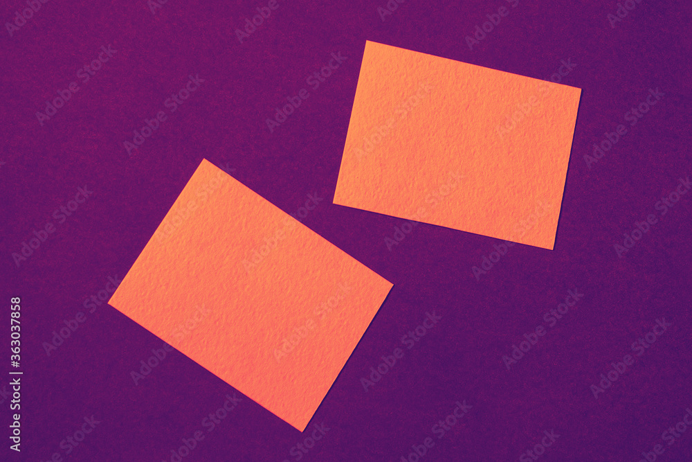 orange paper cards on purple background arranged in random manner, ad mockup in bright intense vibrant colors orange paper cards on purple background arranged in random manner, ad mockup in bright intense vibrant colors