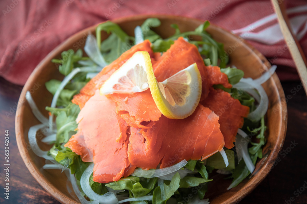 salmon salad with arugula and lemon garnish