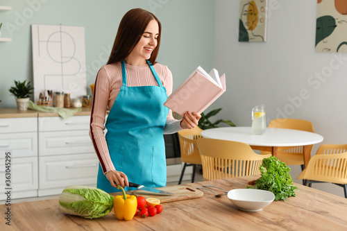 Young woman with recipe boo...