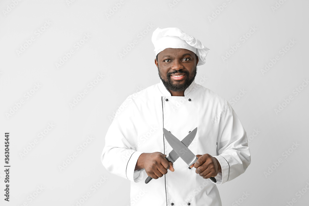 Male African-American chef with knives on white background Male African-American chef with knives on white background