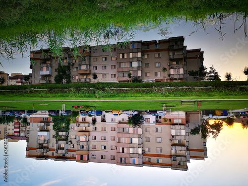 Residential Buildings By Lake Against Sky In City