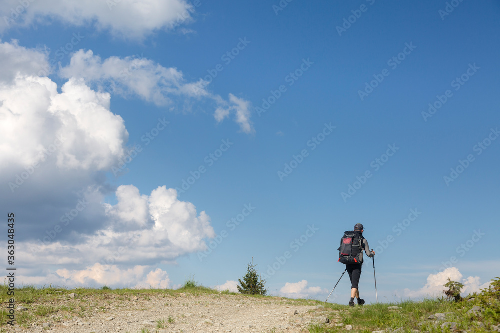 Tourist follow the path, the blue sky on the horizon. Hiking travel outdoor concept panoramic view
