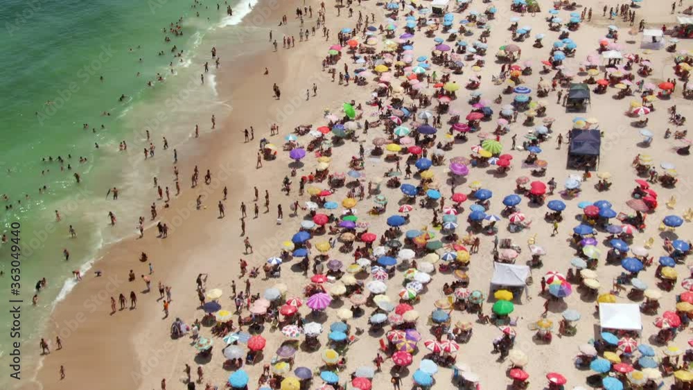 Rio de Janeiro, Brazil, aerial view of Copacabana Beach showing colourful sun umbrellas and people bathing in the ocean during summer. Rio de Janeiro, Brazil, aerial view of Copacabana Beach showing colourful sun umbrellas and people bathing in the ocean during summer.