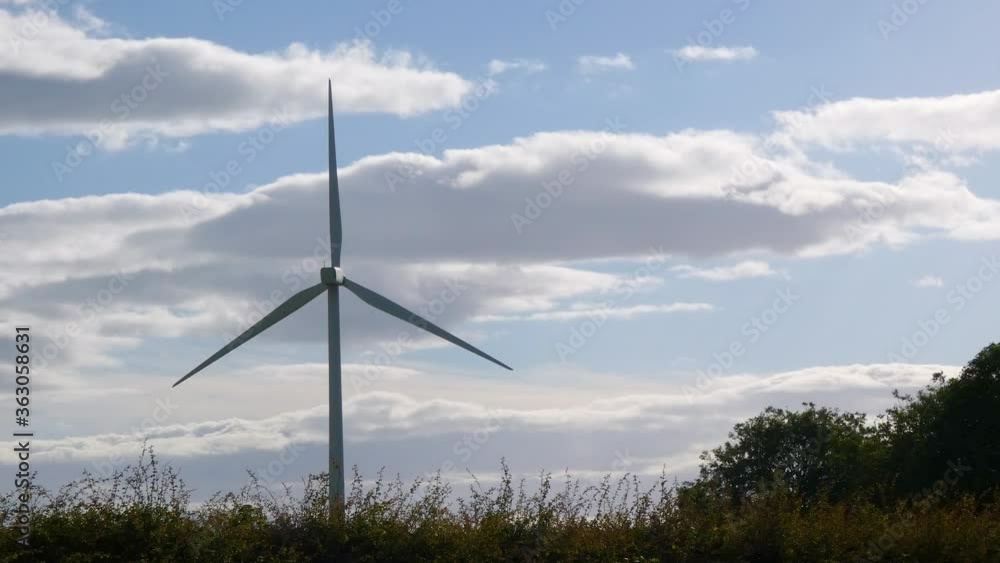 Wind Turbine spinning in the wind in front of the clouds to produce energy Wind Turbine spinning in the wind in front of the clouds to produce energy