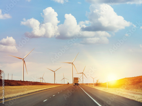 Wind turbines along highway at sunset © SunnyS