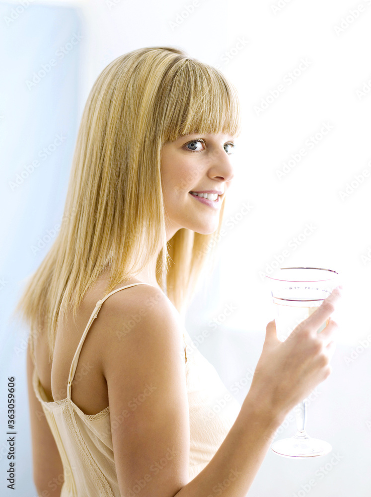 A woman holding a glass of water