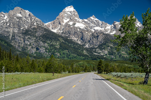 The scenic road through Grand Teton National Park. Leading lines to the Rocky Mountains in Wyoming. Concept for road trip vacation