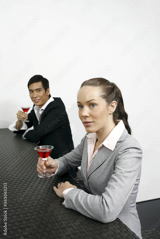 Businessman and businesswoman with glasses of red wine Businessman and businesswoman with glasses of red wine