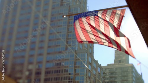 A US flag waving outside a building in New York City in a sunny day.