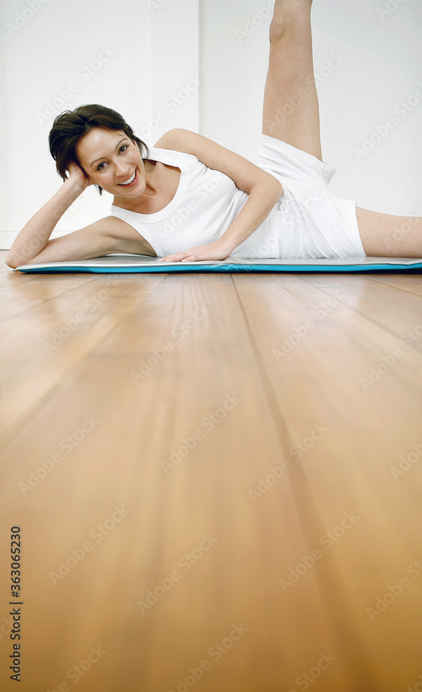 Obraz premium Woman lying on yoga mat