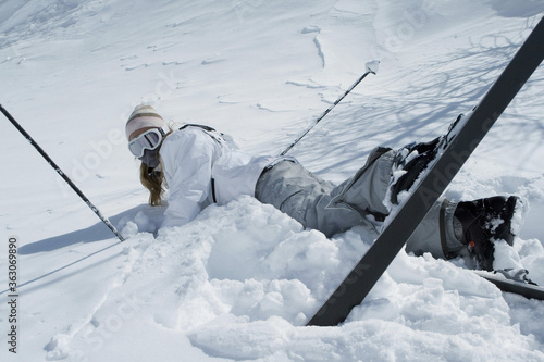 Woman fall down while skiing