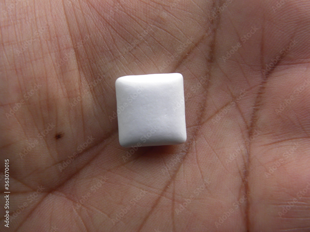 Obraz premium Small white Chewing gum on palm of hand