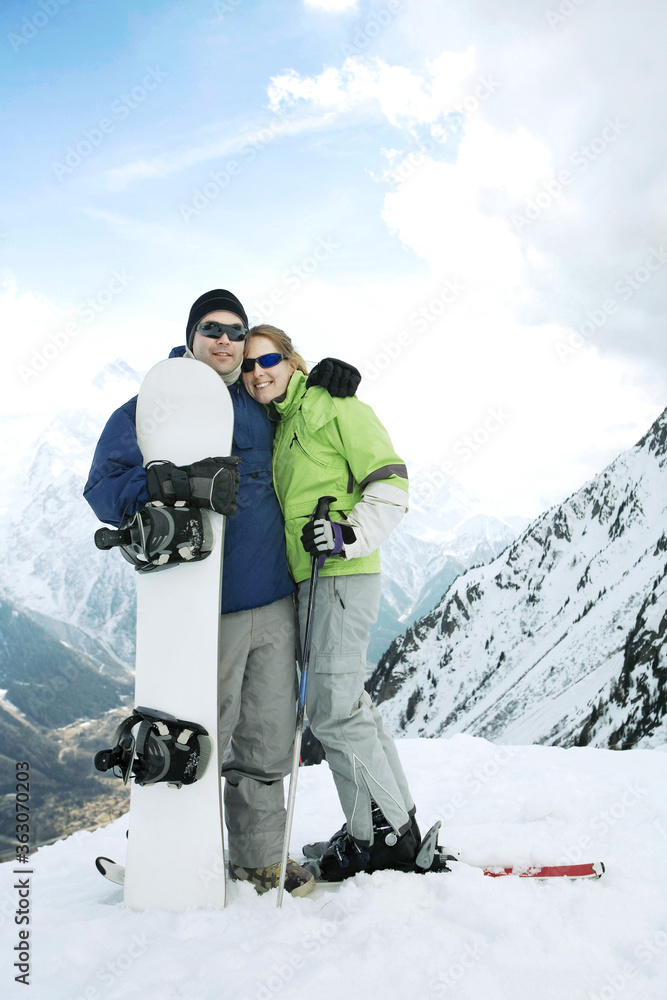 Male snowboarder and female skier