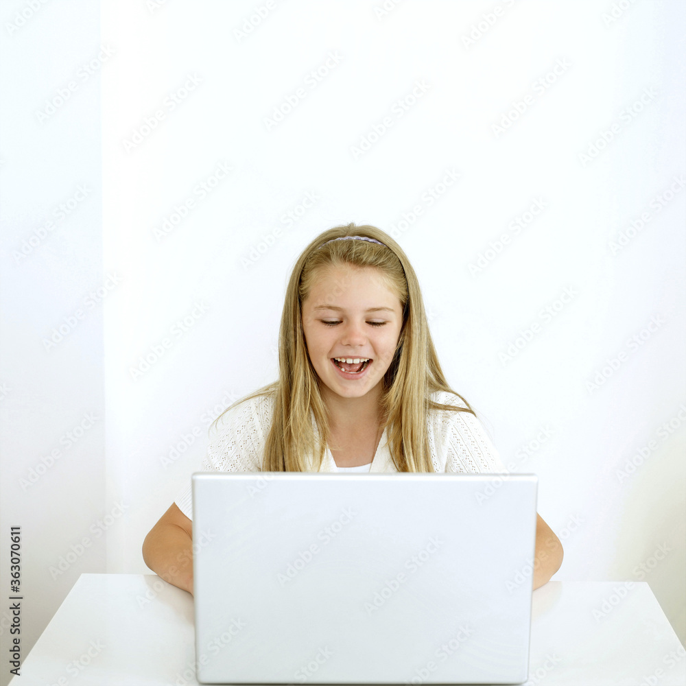 Girl laughing while using laptop Girl laughing while using laptop