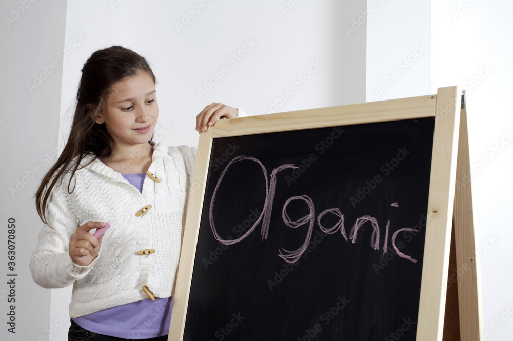Girl looking at the word 'Organic' on the blackboard Girl looking at the word 'Organic' on the blackboard