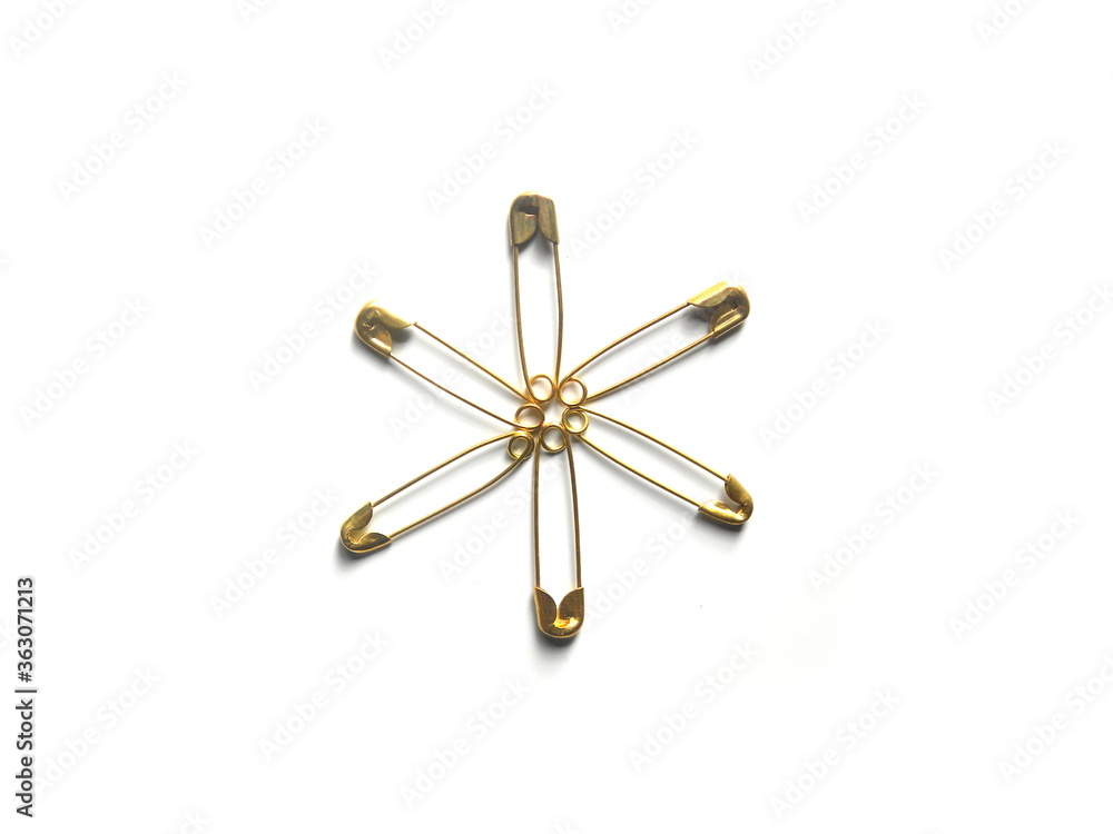 Many golden color safety pins on white background Many golden color safety pins on white background