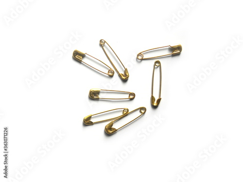  Many golden color safety pins on white background