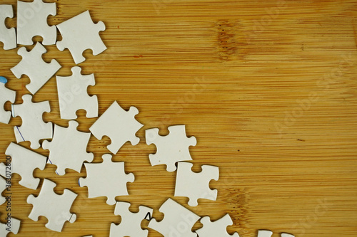 random jigsaw puzzle incomplete concept on wooden background. Copy space for text