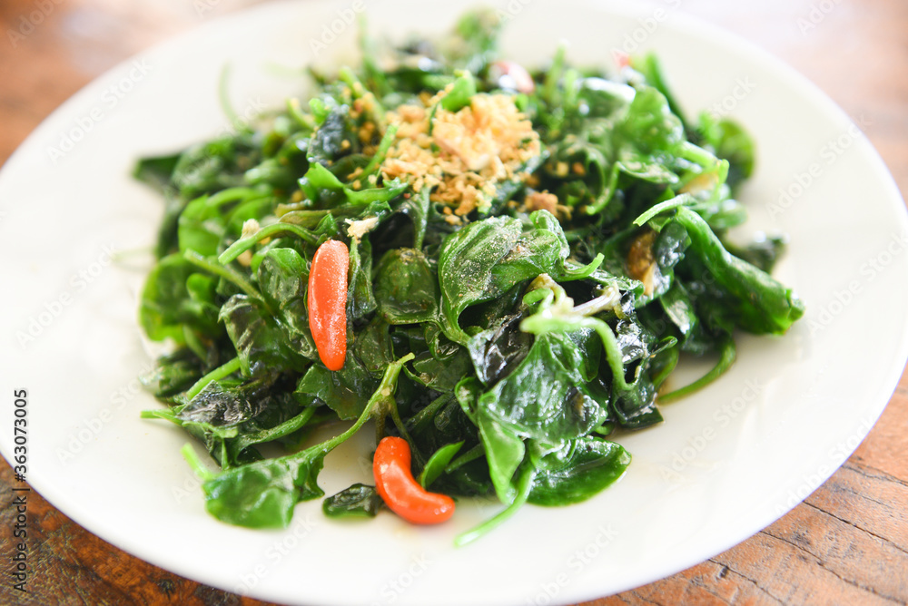 Stir fried oyster sauce watercress vegetable on white plate - Health food green vegetables cooked food in thailand Stir fried oyster sauce watercress vegetable on white plate - Health food green vegetables cooked food in thailand
