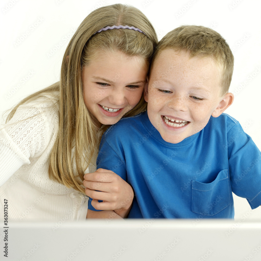 Boy and girl laughing while using laptop Boy and girl laughing while using laptop