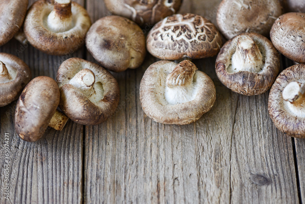 Shiitake mushrooms - Fresh mushrooms on wooden table background Shiitake mushrooms - Fresh mushrooms on wooden table background