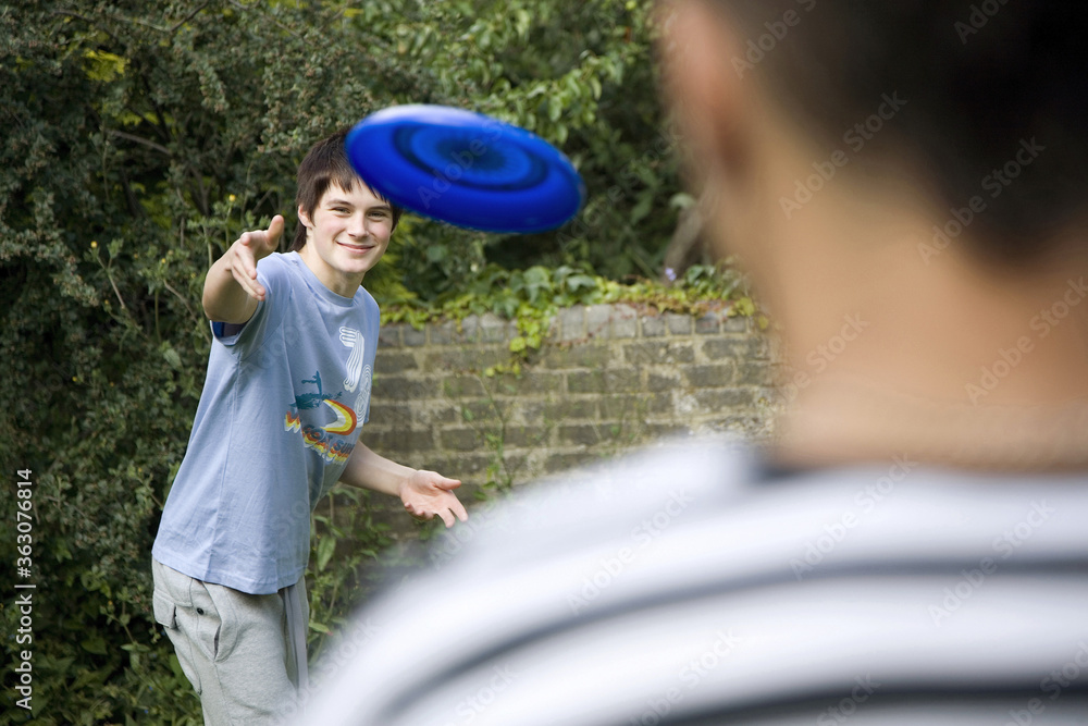 Fototapeta premium Boys playing Frisbee in the park