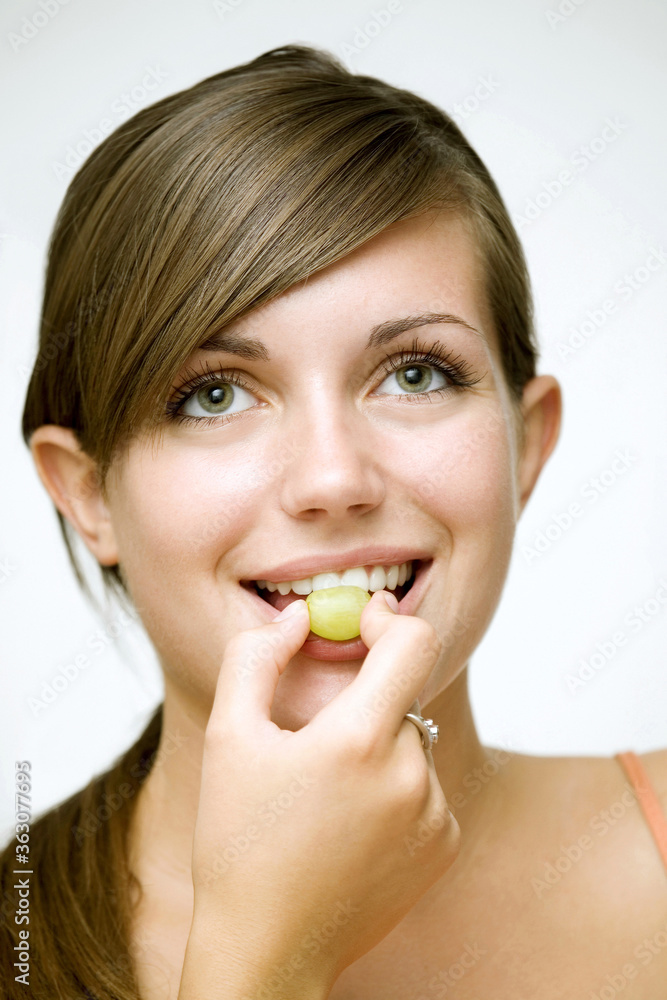 Girl eating green grape