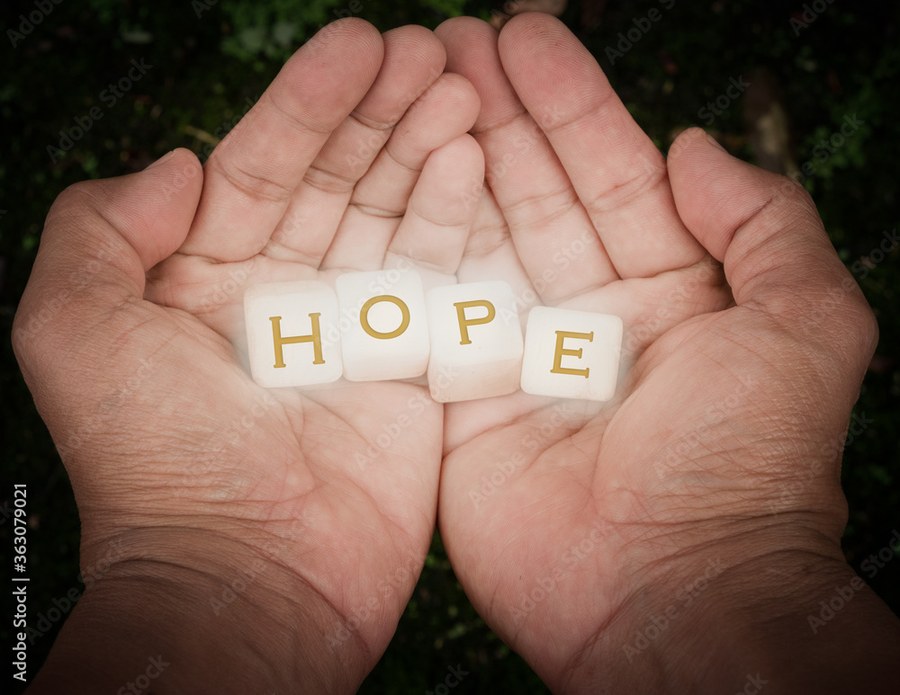 Alphabet in wood Blocks in hands for illustration of hope Alphabet in wood Blocks in hands for illustration of hope