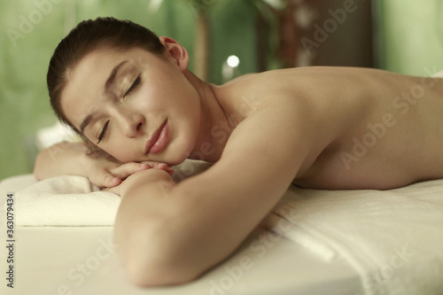 Woman lying forward on the massage table with her eyes closed